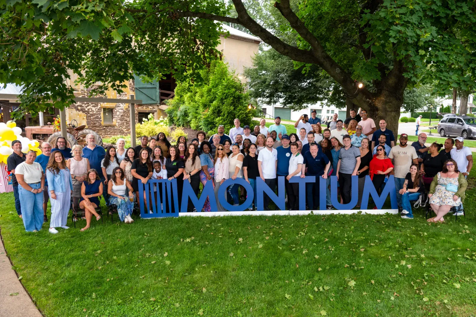 A photo of the entire Montium team standing by their sign.