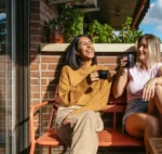 Two Women Drinking Coffee on Balcony